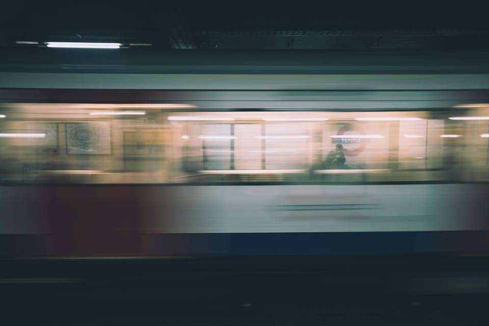 A train passing a platform, blurred with speed
